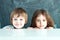 Boy and girl hiding behind a table