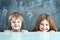 Boy and girl hiding behind a table