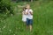 A boy with a girl playing in a field with dandelions.