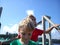 Boy and girl posing on a pier. Red and green t-shirts without patterns. Children play near metal structures in the port. Ships and