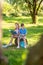 Boy and girl reading on tree stump in park