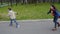 Boy and girl ride in autumn park road on rollers