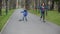 Boy and girl ride in autumn park on rollerblades and scateboard