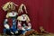 Boy and girl scarecrows sitting by antique red wooden barn