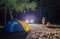 Boy and girl sit at night tourists tent.