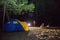 Boy and girl sit at night tourists tent.