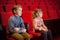 Boy and girl sitting on armchairs at cinema