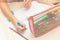 A boy and a girl are sitting on the couch at the table and drawing with paints and felt-tip pens