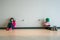 Boy and girl sitting on a floor concentrating and playing electronic games.