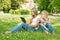 Boy and girl sitting in the park and enjoy the tablet