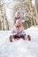 Boy And Girl Sledging Through Snowy Woodland