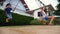 Boy and girl teenager swinging on a swing with bare feet on the green lawn of the backyard of his house