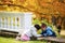 Boy and girl toddlers playing in autumn leaves