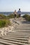 Boy And Girl Walking On Boardwalk Toward Sea