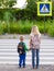 Boy and girl want to cross the road at a pedestrian crossing