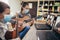 Boy and girl, wear protective masks, playing acoustic guitar and watching online course on laptop while practicing at home.