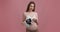 Boy or girl. Young pregnant lady with naked belly holding ultrasound photography of baby with blue and pink stickers