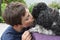 Boy gives kisses to his toy poodle