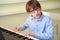 Boy with glasses learns to play the synthesizer.