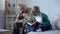 Boy in glasses reading book for grandfather, old man falling asleep on cosy sofa