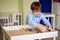 Boy glasses is sand therapy on table with light