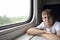 Boy with glasses sits at table in compartment carriage. Child travels by train. Travel by railway