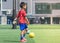 Boy with goalkeeper gloves standing on a training field