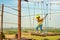 The boy goes on logs on the cable car in an extreme park.