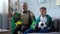 Boy and granddad holding Brazil flags, watching football, worrying about game