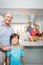 Boy with grandfather while family preparing food in background