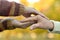 Boy and grandfather hands together over natural background