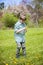 Boy in grass outside picking flowers