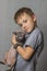 A boy in a gray T-shirt hugs a bald gray Sphynx cat