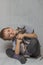 A boy in a gray T-shirt hugs a bald gray Sphynx cat