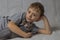 A boy in a gray T-shirt hugs a bald gray Sphynx cat