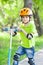 Boy in green jacket stands with kick scooter