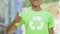 Boy in green shirt with recycle symbol showing thumbs up, environment protection