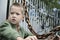 Boy in a green sweater holds a rusty chain