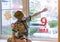 A boy in a green t-shirt and a Soviet cap with a star glues a paper crane on the window on may 9-a symbol of victory