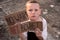 A boy with a grimy face and sad eyes holds a cardboard poster with the inscription NO WAR