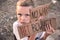 A boy with a grimy face and sad eyes holds a cardboard poster with the inscription NO WAR