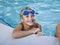Boy grinning, hanging on to side of swimming pool