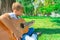 A boy with a guitar sits under a tree, wide angle photo