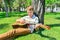 A boy with a guitar under a tree, a teenager plays and sings in the park