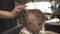 Boy hairstyle with dryer in barbershop. Children hair drying in barber salon. Hairdresser styling hair little boy with