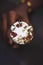 Boy hand holding an butterscotch ice cream cone with cashew nuts ice cream on a dark background