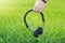 Boy hand holding wireless headphone on green nature background