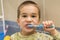 the boy has been brushing his teeth in the bathroom for 4 years. close-up. little boy brushes teeth in a bathroom.