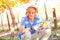 Boy in hat and blue t-shirt harvesting ripe grapes