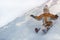 Boy in hat and orange jumpsuit slides off snow slide on back. Portrait. Close-up. Winter day